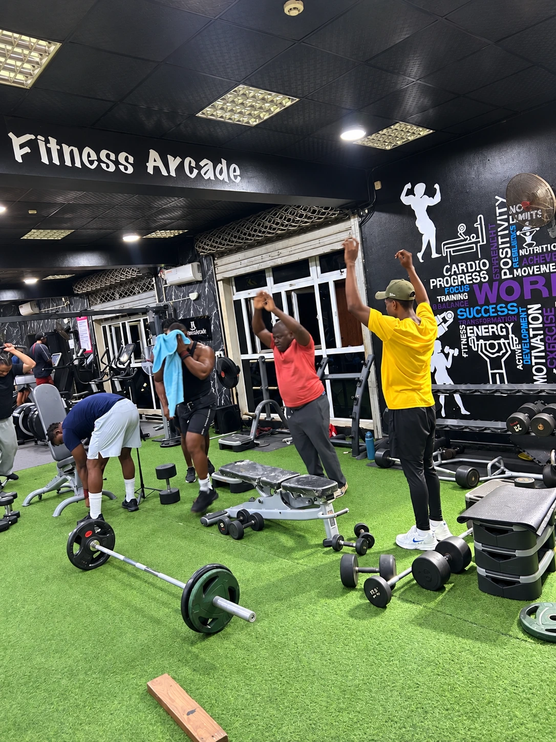 Members exercising with weights and steps on the Fitness Arcade gym floor